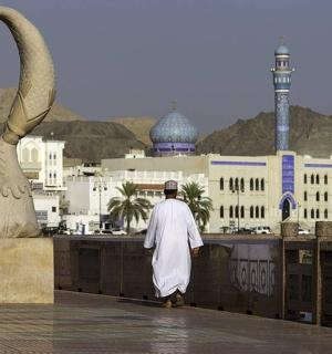 一名男子走在带有两只天鹅雕像的壁架上