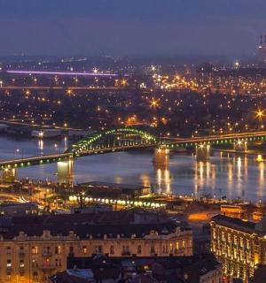 a city with a bridge over a river at night