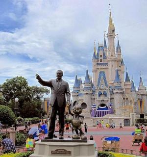 a statue of a man in front of a castle