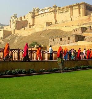 a group of people standing on a fence in front of a building