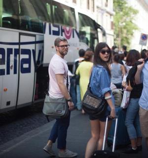 a group of people standing outside of a bus