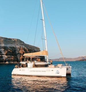 ein weißes Boot im Wasser neben einer Klippe