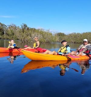 a group of people sitting in kayaks on the water