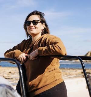 žena se slunečními brýlemi stojící na pláži