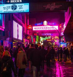 a crowd of people walking down a street at night