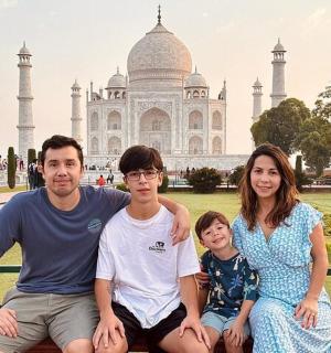 una famiglia seduta su una panchina di fronte al Taj Mahal