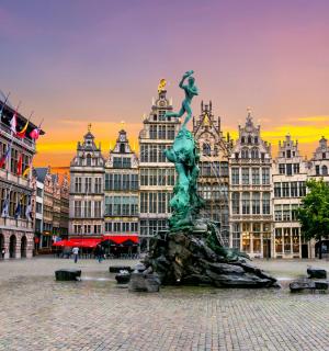 a statue in the middle of a city with buildings