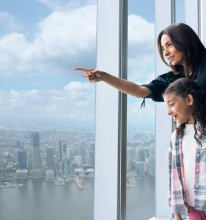 a woman pointing at a window in a skyscraper