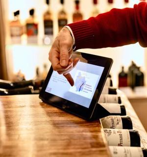 a person is pointing at a laptop on a table