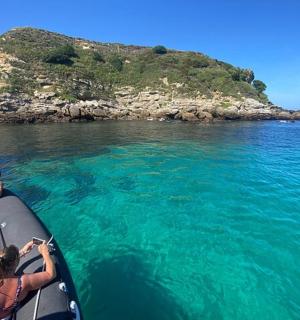 zwei Personen, die auf dem Heck eines Bootes im Wasser fahren