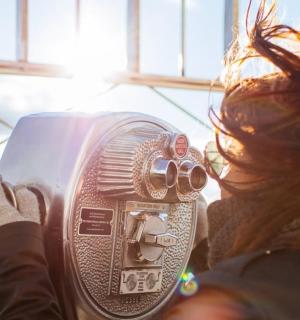 a woman holding a hair dryer in front of a window