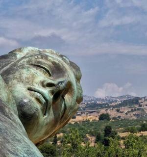 a statue of a woman looking at a city