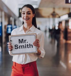 一名女子举着写着“史密斯先生”的牌子