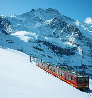 a red train traveling down a snow covered mountain