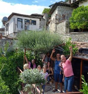 a group of people standing outside a house with their hands in the air