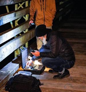 a man sitting on the floor looking at his cell phone