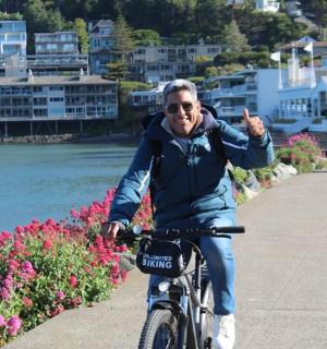a man riding a bike down a sidewalk