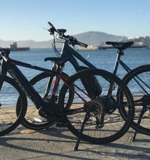 a bike parked on a sidewalk next to the water