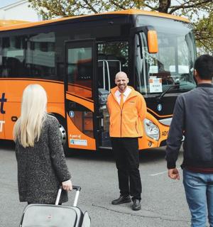 three people standing in front of a bus