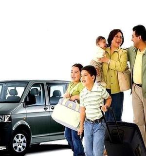 一家人带着行李站在汽车旁边