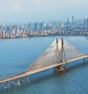 a bridge in the water with a city in the background