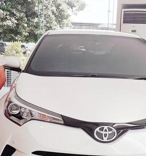 一名男子站在一辆白色汽车旁边