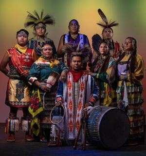 skupina lidí oblečených v tradičním oblečení pózujících pro fotografii