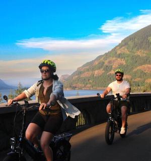 zwei Männer fahren mit dem Fahrrad auf einer Brücke über einem Fluss