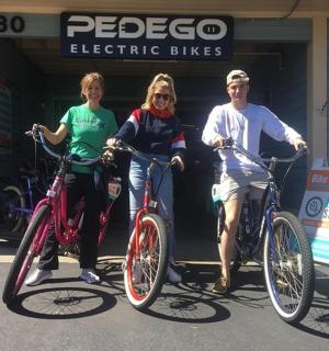 三个人在商店前与自行车合影