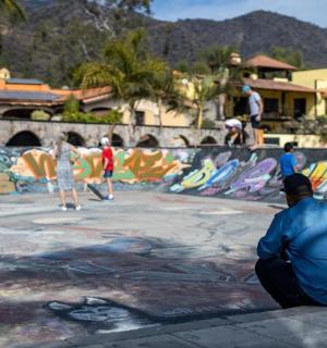 un uomo seduto a terra davanti a uno skate park
