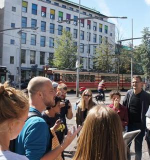 一群人站在街上，旁边有一辆公共汽车