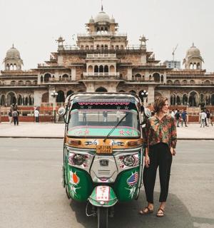 a woman standing next to a motorcycle in front of a building