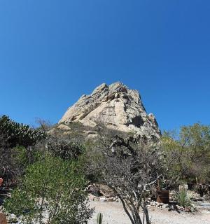 a large rock in the middle of a beach with people