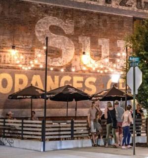 a group of people standing outside of a building with umbrellas