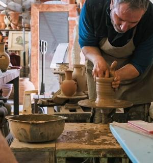 ein Mann, der eine Vase auf einer Töpferscheibe herstellt