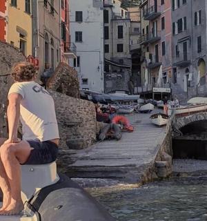 一名男子坐在水中的船尾