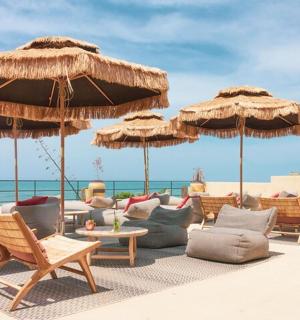 eine Gruppe von Stühlen und Sonnenschirmen am Strand