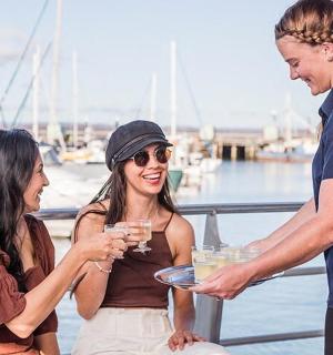 一名男子递给一名女子一盘酒杯