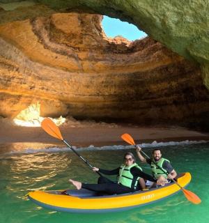 两个人在洞穴前的皮划艇上