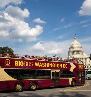 dvoupatrový autobus zaparkovaný před budovou Kapitolu