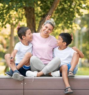 naine istub pingil kahe poisiga