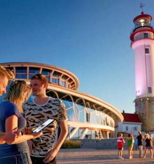 a group of people standing in front of a lighthouse