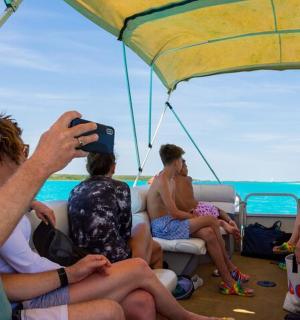 一名男子正在为船上的一群人拍照