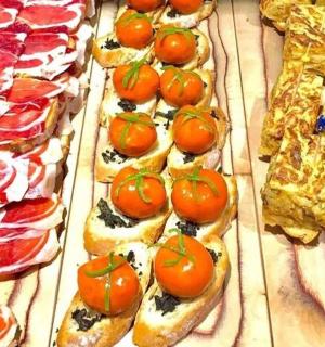 a bunch of pizzas with tomatoes on top of them