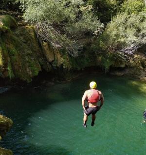 滝の近くの水たまりに飛び込む男性