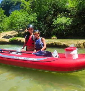 水上の赤いボートに乗った女性と子供