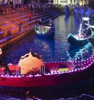 a church with gondolas in the water with lights