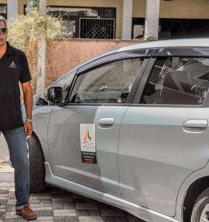 a man standing next to a silver car