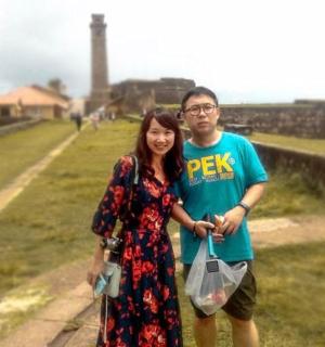 a man and a woman posing for a picture on a wall