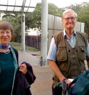 an older man and woman standing next to each other